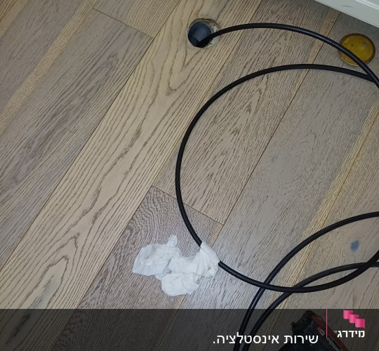 כבל וכלי עבודה על רצפת עץ